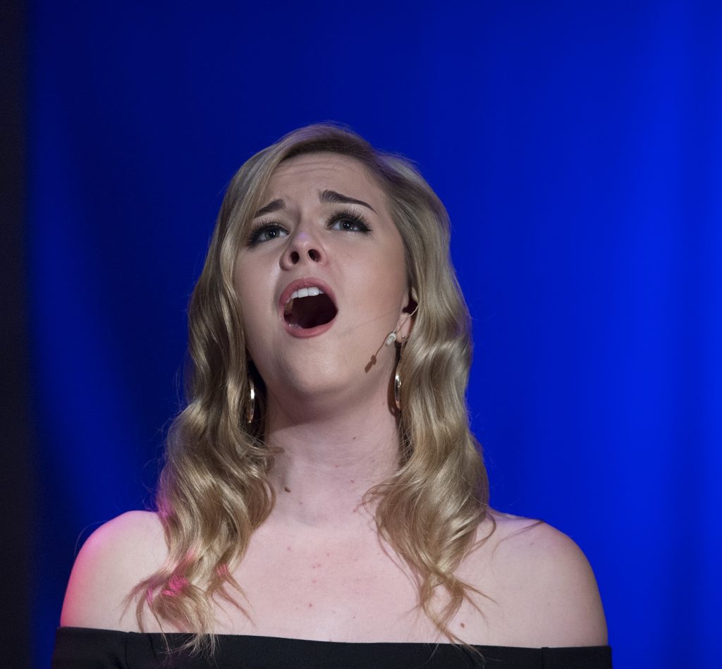 A solo performing arts student sings expressively.