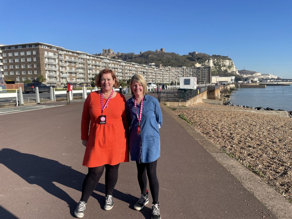 Dawn and Laura the chief executive officers standing outside on the beach front with Dover Castle behind them.