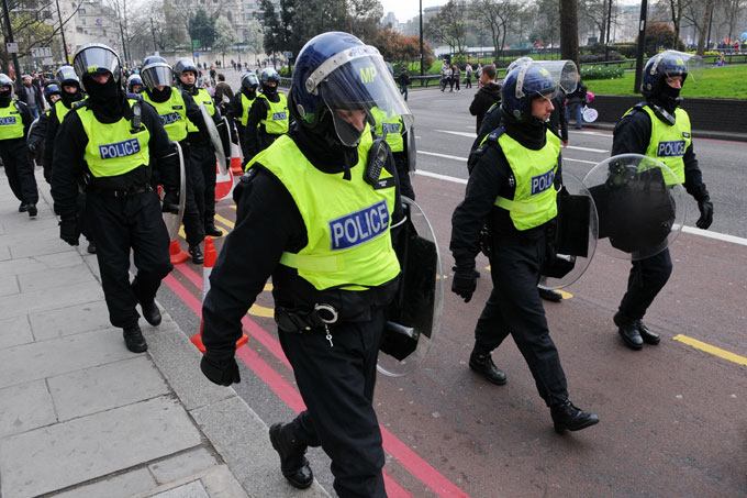 UK riot police marching along a street