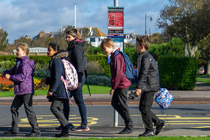 School children outside at a bus stop