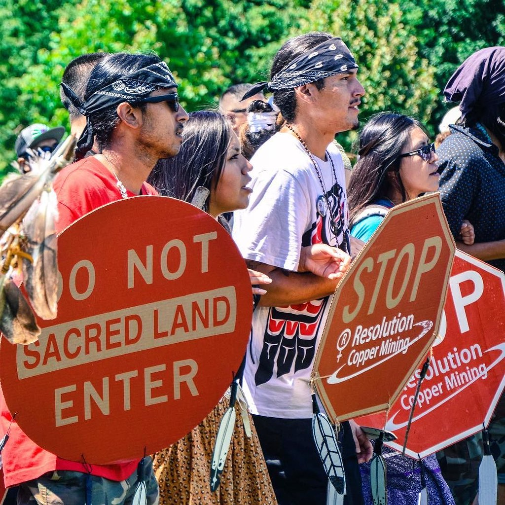 Native American protesters holding DO NOT ENTER SACRED LAND and STOP RESOLUTION COPPER MINING signs