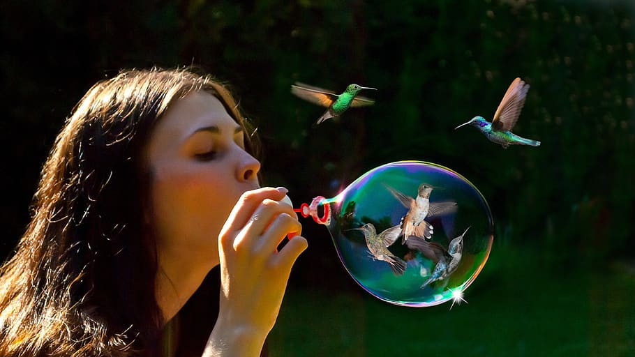 woman blowing bubbles with birds