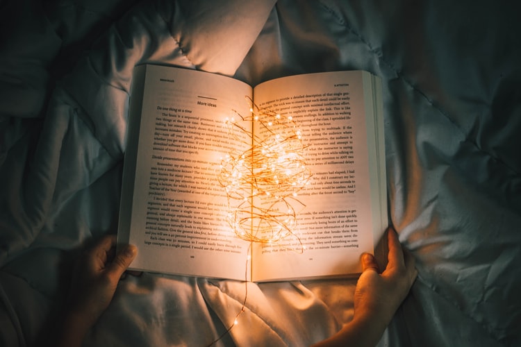 an open book with string lights