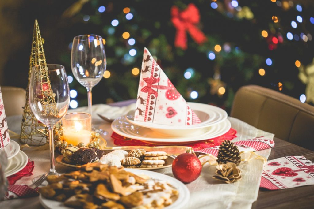 A Christmas dinner table, with a Christmas tree in the background