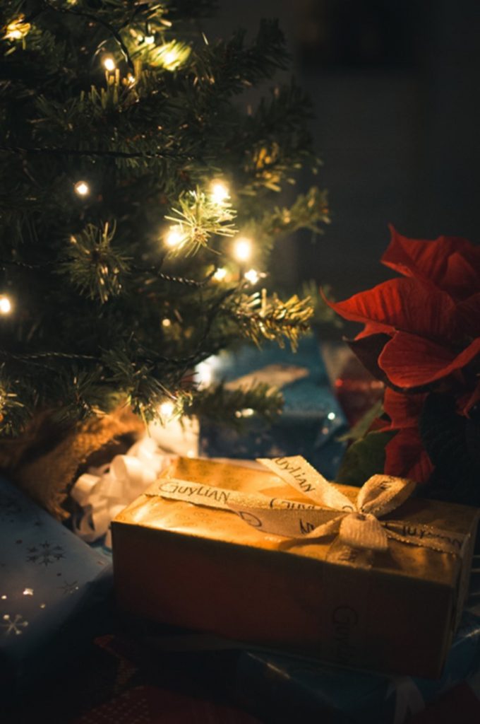 Christmas presents under a Christmas tree with lights