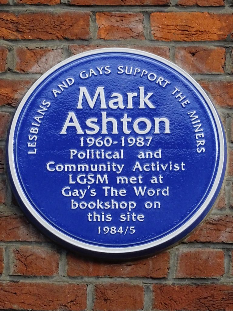 A photograph of the blue plaque at Gay's the Word commemorating Mark Ashton and LGSM. The Plaque reads: Lesbians and Gays Support the Miners, Mark Ashton 1960-1987, Political and Community Activist, LGSM met at Gay's the Word bookshop on this site 1984/5.