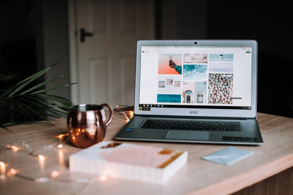 a working station with laptop, mug and book