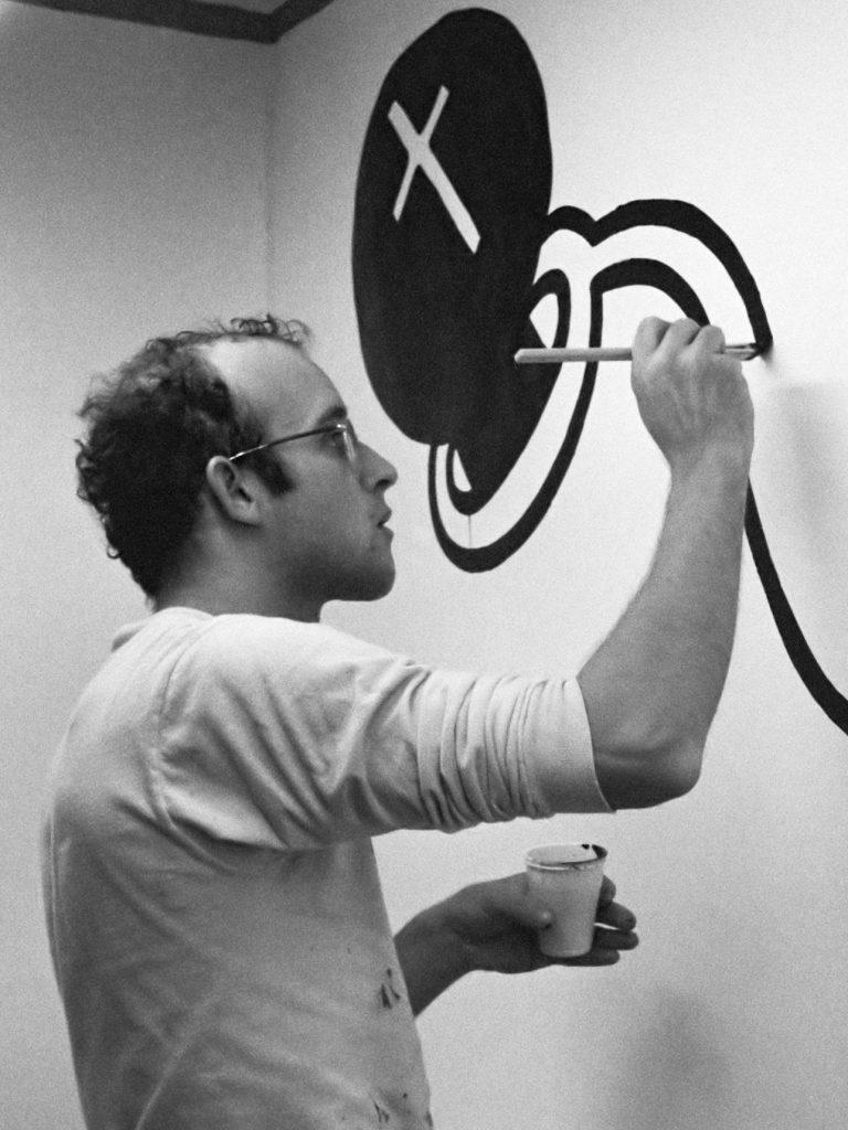 Black and white photo of Keith Haring painting a mural