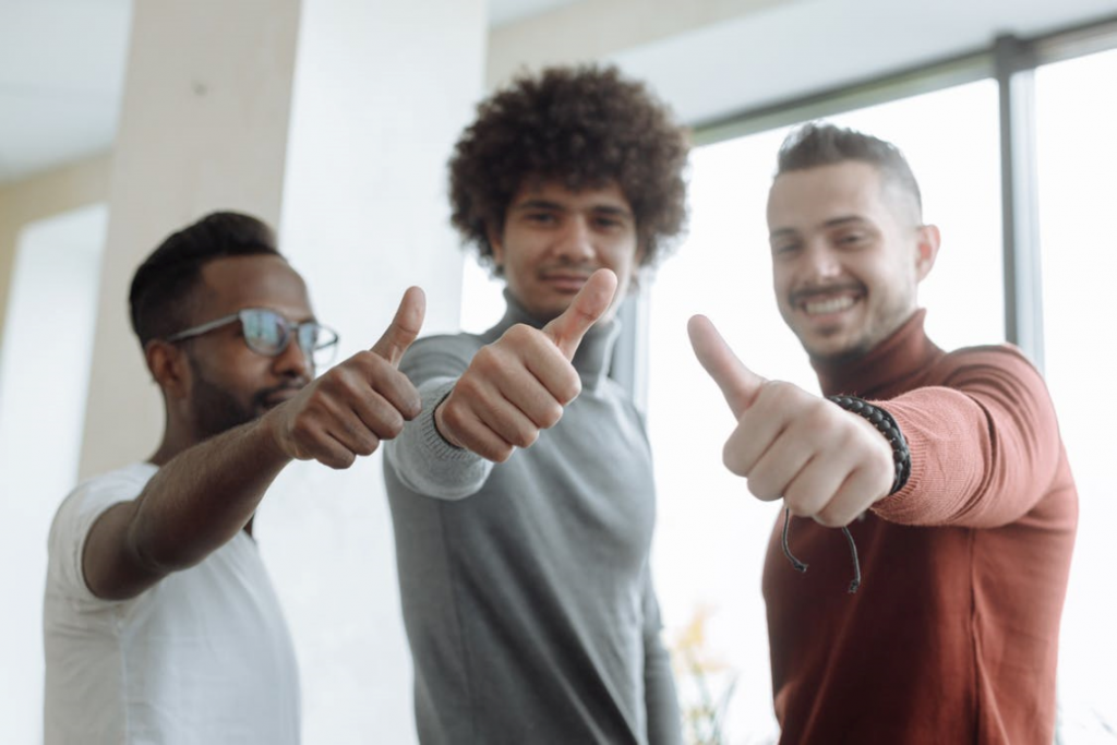 three guys with thumbs up