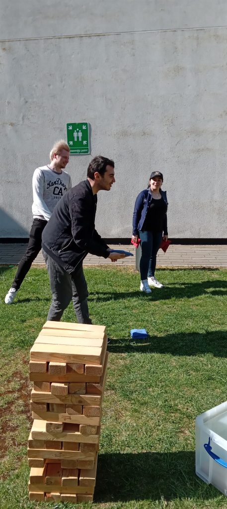 staff and student playing bean bag toss