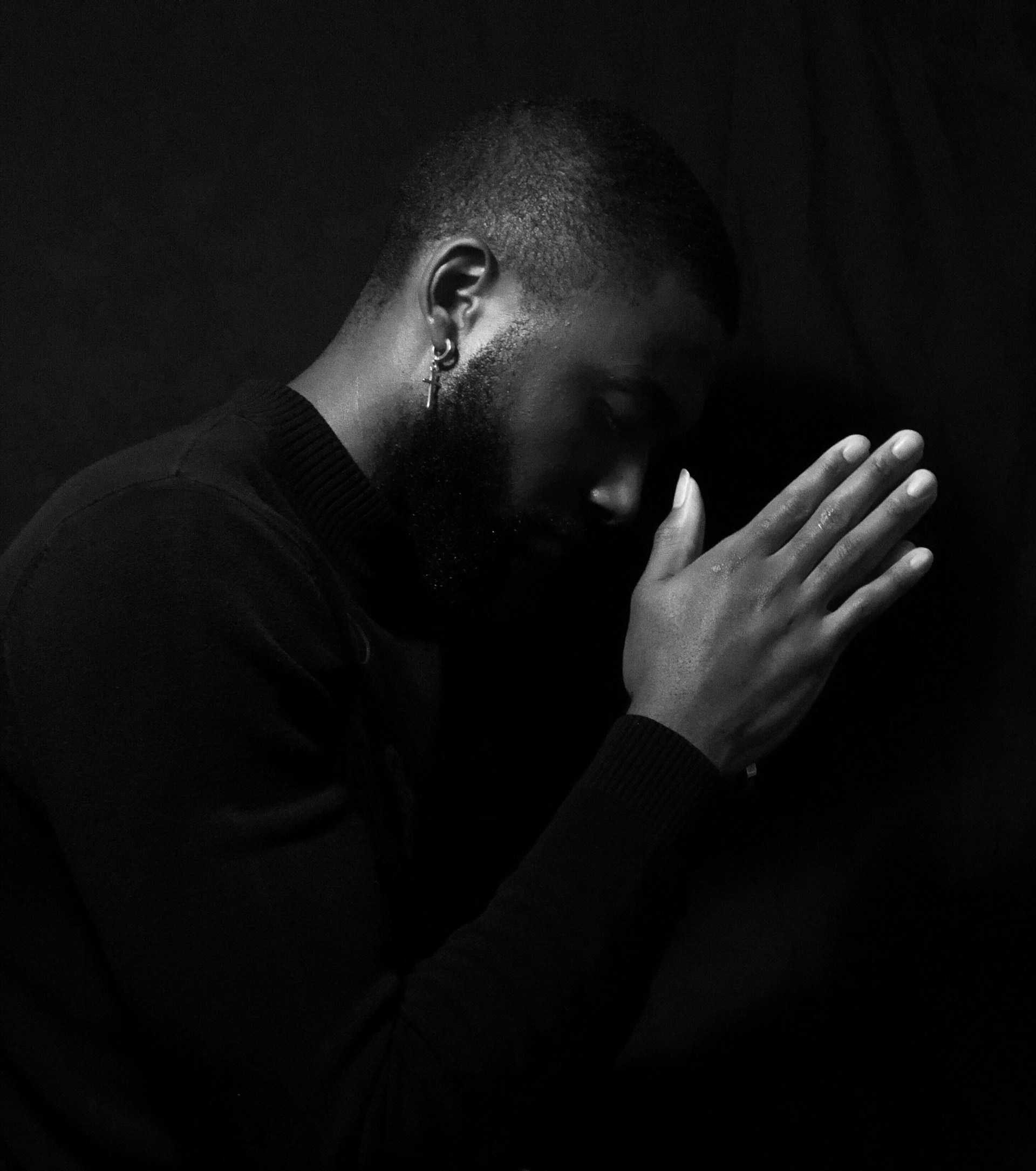 Photo of Black Man with hands together praying.