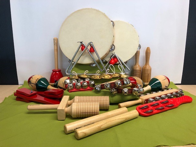 a percussion set of metal, plastic and wooden instruments including Guiro, wooden agogo, woodblock, tambourines, tulip block, bell jingles, jingle sticks, finger cymbals, indian bells, triangles, claves, castanets and maracas.