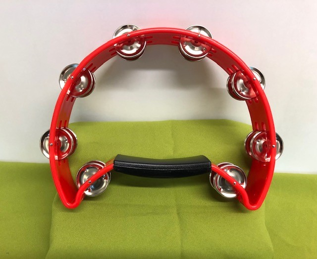 A large, almost circular tambourine with metal discs and a solid plastic handle.