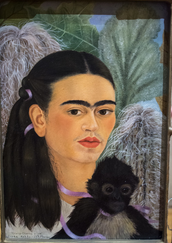 Painting of Frida Kahlo with her pet monkey on her shoulder.