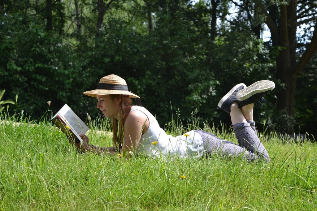 Woman / girl laying on her front on the grass reading a book. 
Downloaded from Pixabay and created by BibBornem
https://pixabay.com/users/bibbornem-217673/


