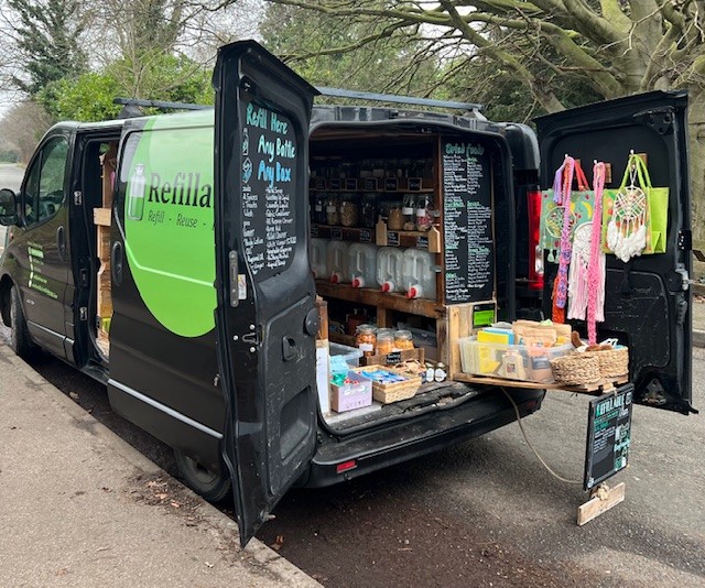 Photo of the Refillable Van with doors open displaying goods for sale.