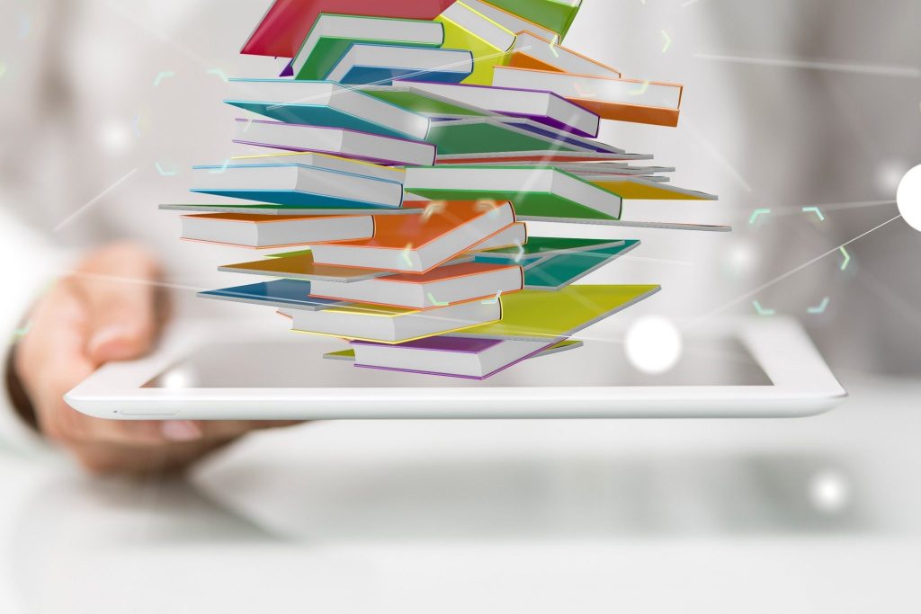Animated created image of someone holding an i-pad which has print books swirling out of the i-pad. To represent e-books.
Downloaded from Adobe Stock. 