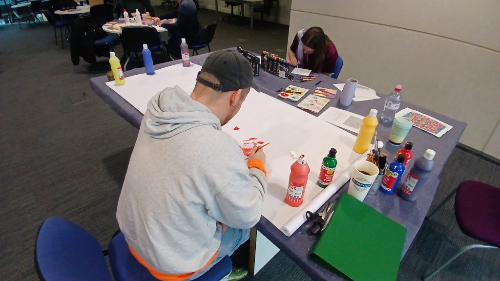 Photo of students painting at StressLess, taken by library staff.