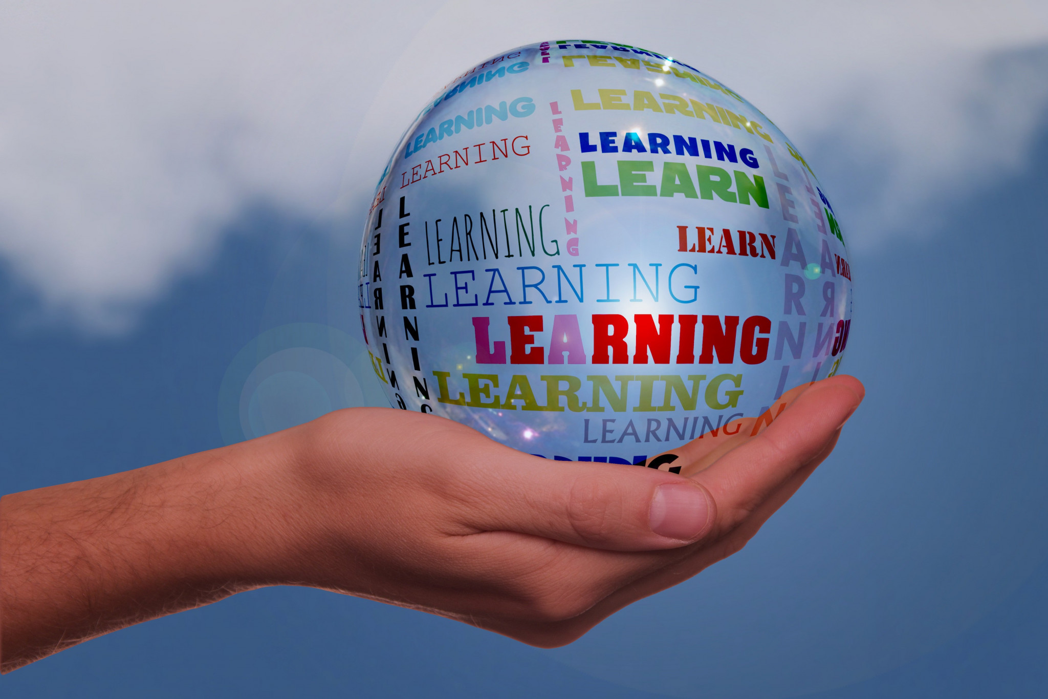 A bubble with the words learning on it held in a hand