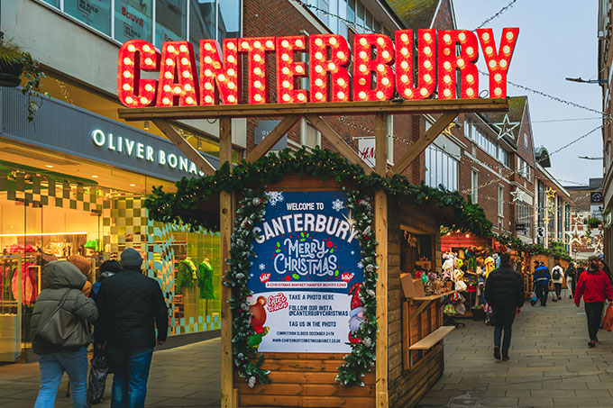 Large illuminated Canterbury sign in Christmas street market