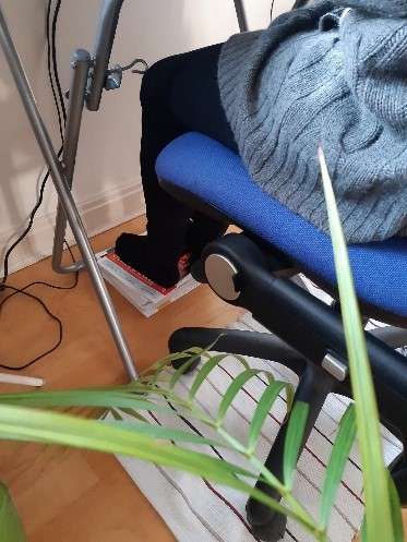 Magazines being used as a foot stall at computer desk