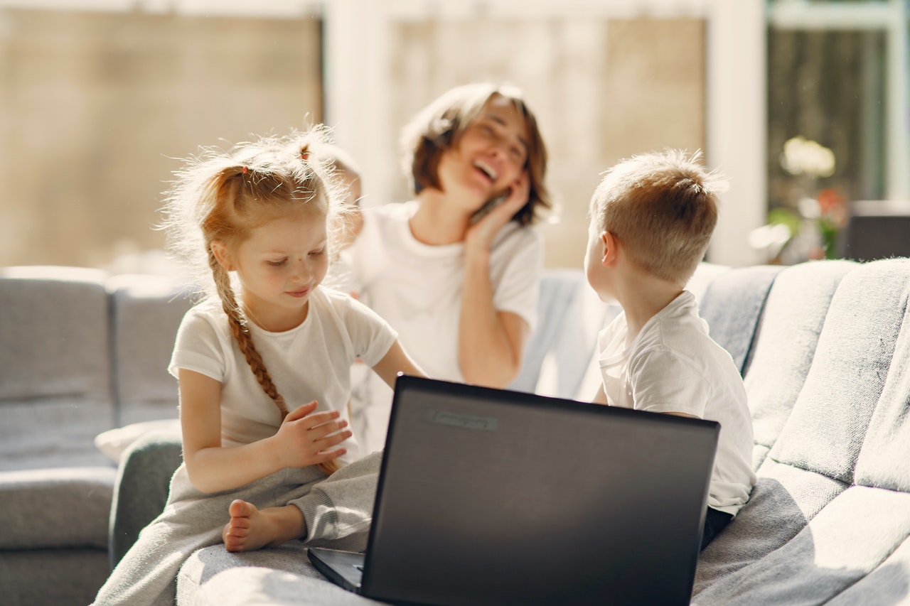 mother on phone with children on laptop