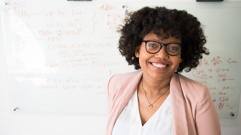 Woman framed to the right smiling at the camera.