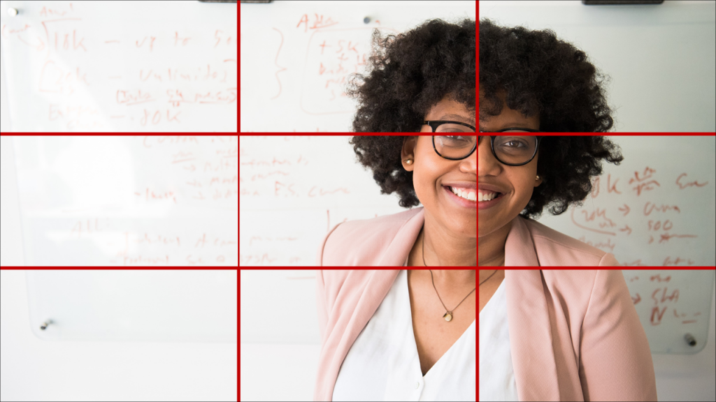 Woman framed to the right smiling at the camera. Grid over image shows how she is framed according to the rule of third.