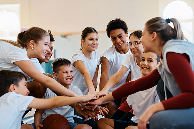 Group of children and a sports coach in a circle